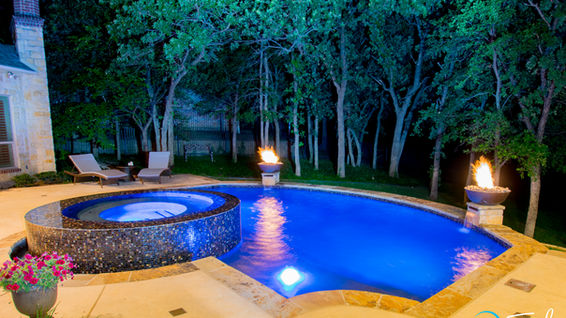 Small cozy Trophy Club pool with raised perimeter overflow circular spa nestled in the trees designed by Mike Farley.