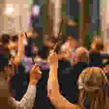 2 people waving harry potter wands to the sky at a convention