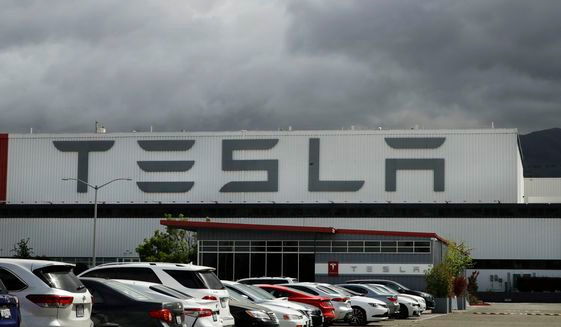 Vehicles are parked outside the Tesla plant, in Fremont, Calif., on May 12, 2020. California sued Tesla Inc. on Wednesday, Feb. 9, 2022, over allegations of discrimination and harassment of Black employees at its San Francisco Bay area factory. (AP Photo/Ben Margot)