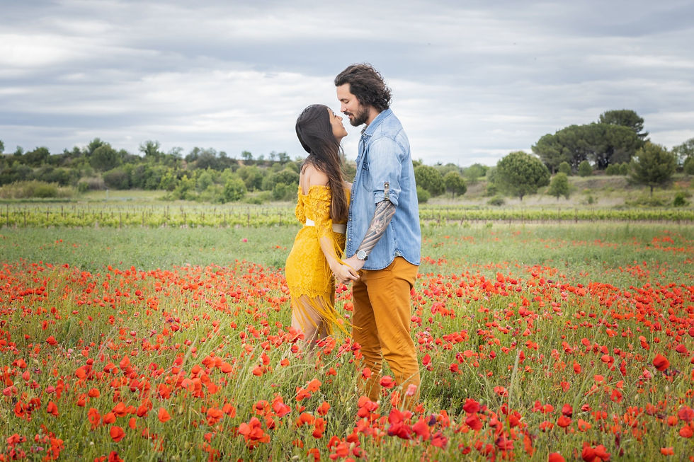 Couple main dans la main dans un champ de coquelicots à Loupian, au printemps, dans le Bassin de Thau