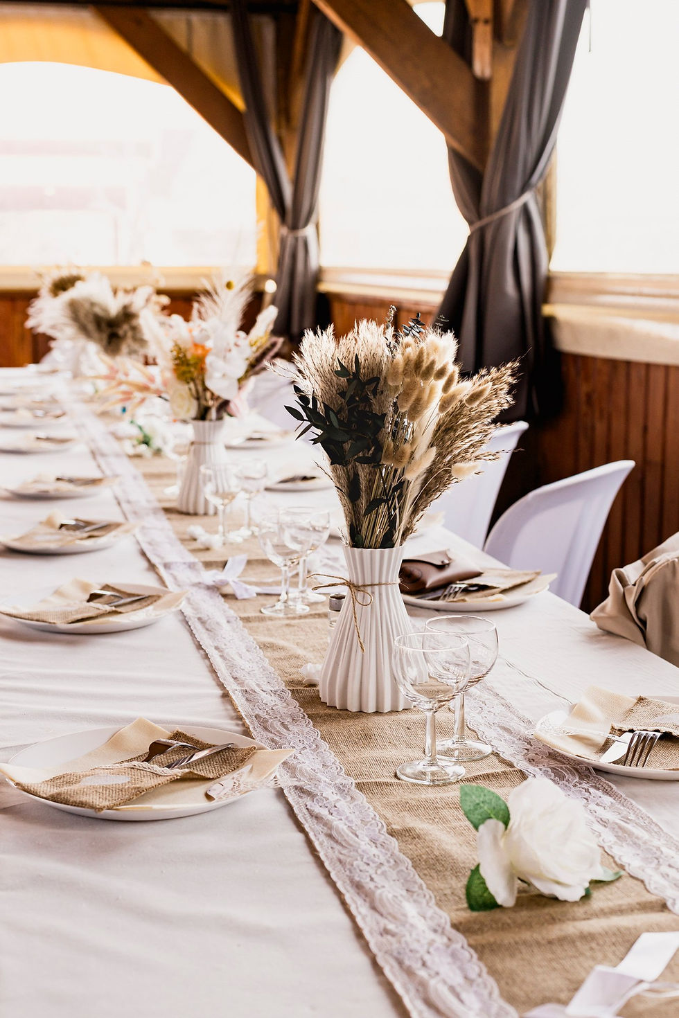 Table de mariage dressée avec des fleurs séchées et un chemin de table en dentelle au Mas Valero