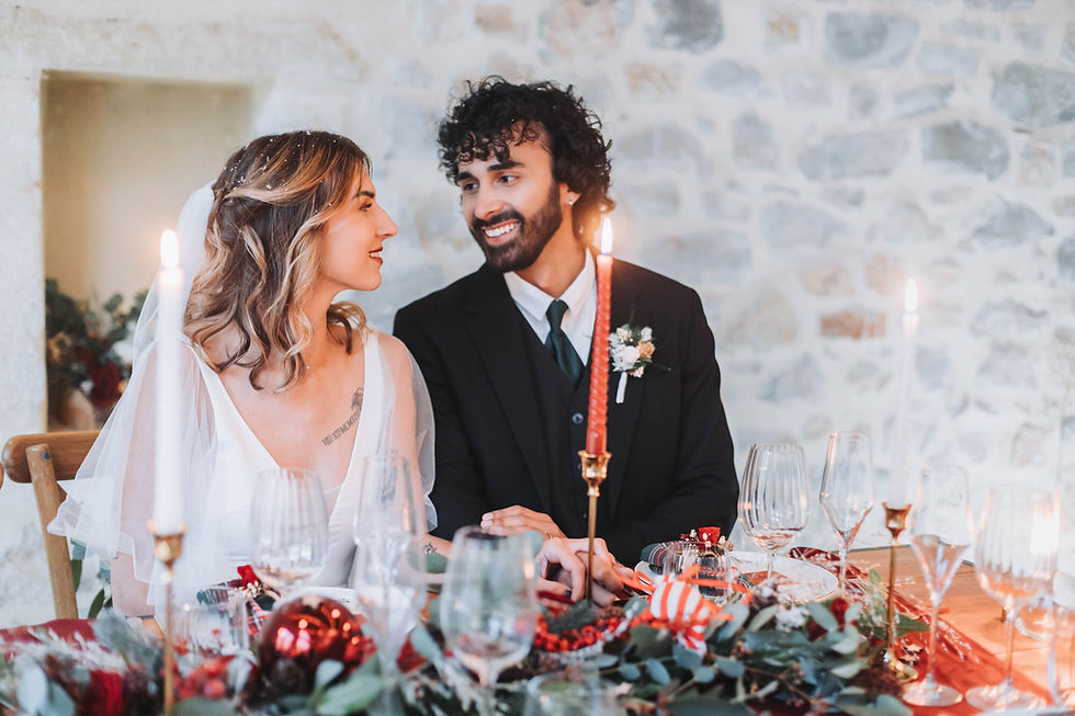 Couple assis à une table décorée pour un shooting d’inspiration mariage de Noël
