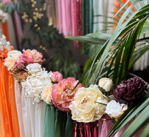 Wedding backdrop with tassels topped with florals