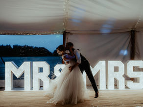Bride and groom standing infront of MR&MRS light up letters at their wedding reception.