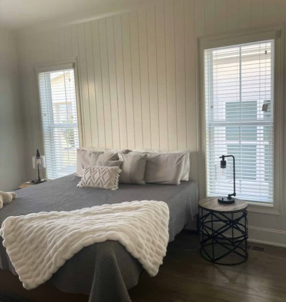 2" wood blinds in a white paint finish in a bedroom over double hung windows.