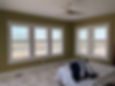 Contemporary bedroom overlooking Bird Island Nature Preserve in Sunset Beach with plantation shutters installed by Carolina Custom Shutters.