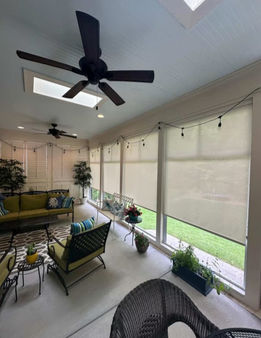 Beige solar shades providing privacy and light control on a covered back porch.