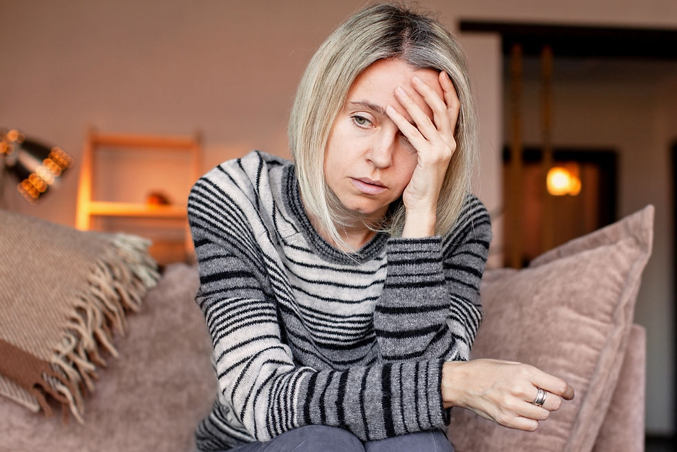 A blonde woman holds her head in distress