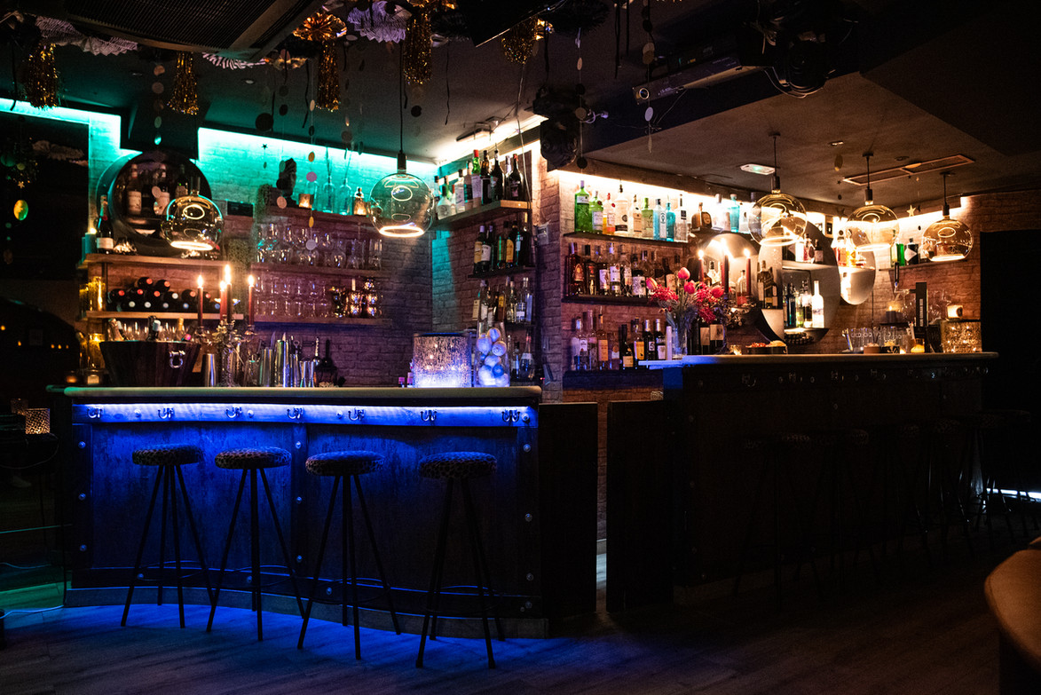 Second half of The Dutchess bar showing wine selection, glassware, and elegant handcrafted bar counter and stools.