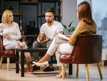 Couple in a therapy session with a counselor during addiction recovery, symbolizing joint healing and support at New Existence Recovery