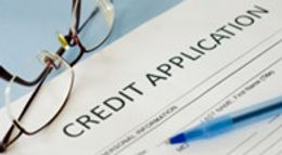 Credit application form with glasses and pen