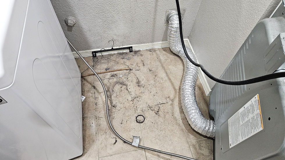 Dirty floor and hose behind a dryer that needs a dryer vent cleaning