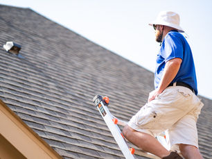 man on the roof doing his summer home maintenance checklist for Dallas-Fort Worth homeowners