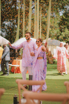 Smiling couple in lavender walking amidst falling confetti