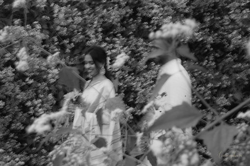 Smiling woman and another person among dense foliage
