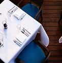 Professional restaurant laundry service cleaning a table linen set - crisp white tablecloths and napkins in a Manchester rest