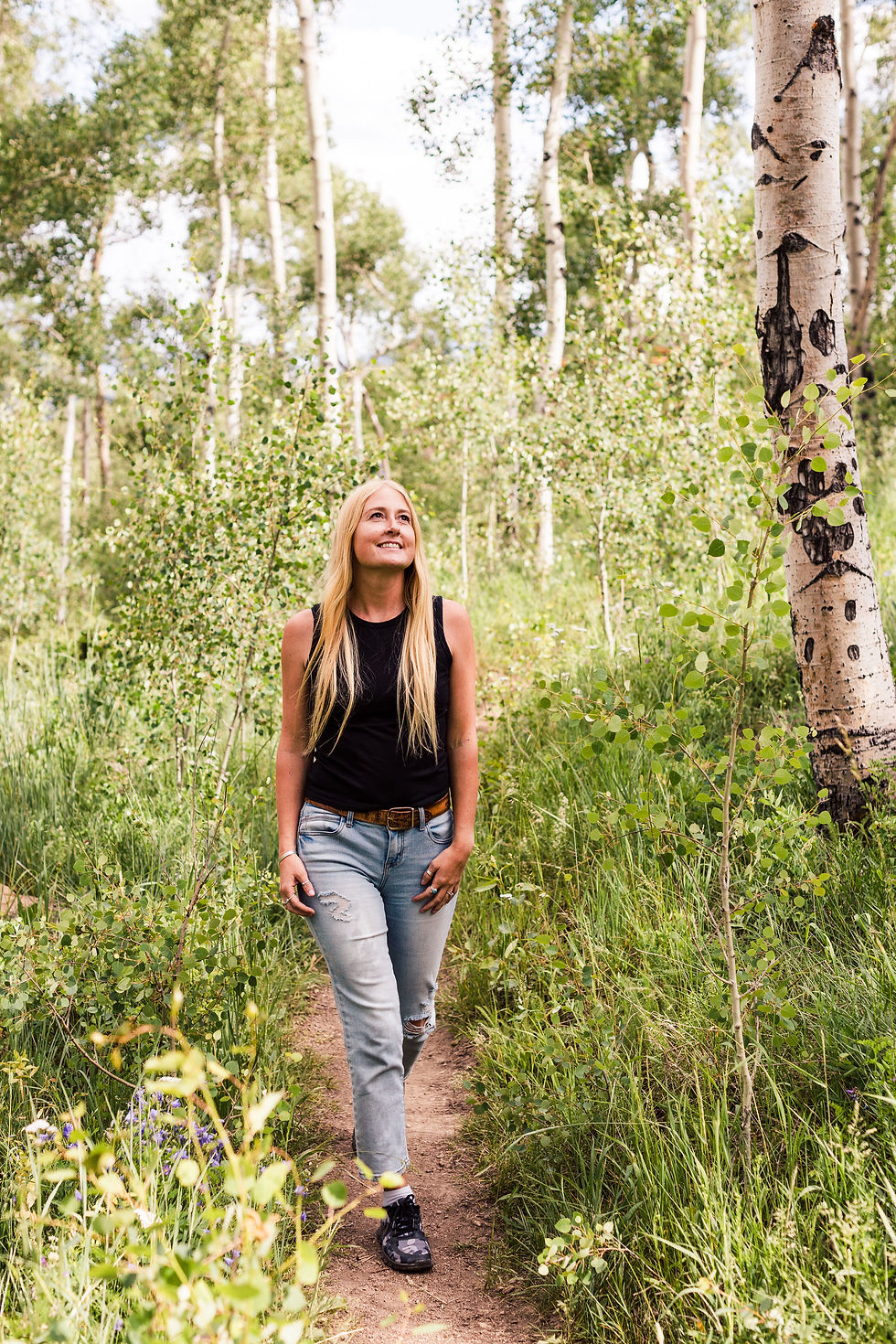 Kianna Stadler walking along a trail through an aspen forest