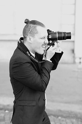 Andrea Siligardi, a wedding photographer based in Byron Bay, Australia, is captured in action, focused behind the lens while documenting a special moment.