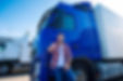 Professional truck driver in front of long transportation vehicle holding thumbs up ready for a new ride Free Photo