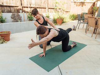 personal trainer helping a client during an exercise