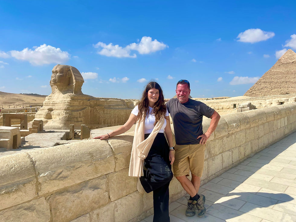 A man and a woman stand in front of the Great Sphinx of Giza