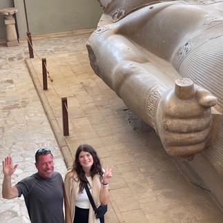 A man and a woman stand next to the Statue of Ramses II in Memphis
