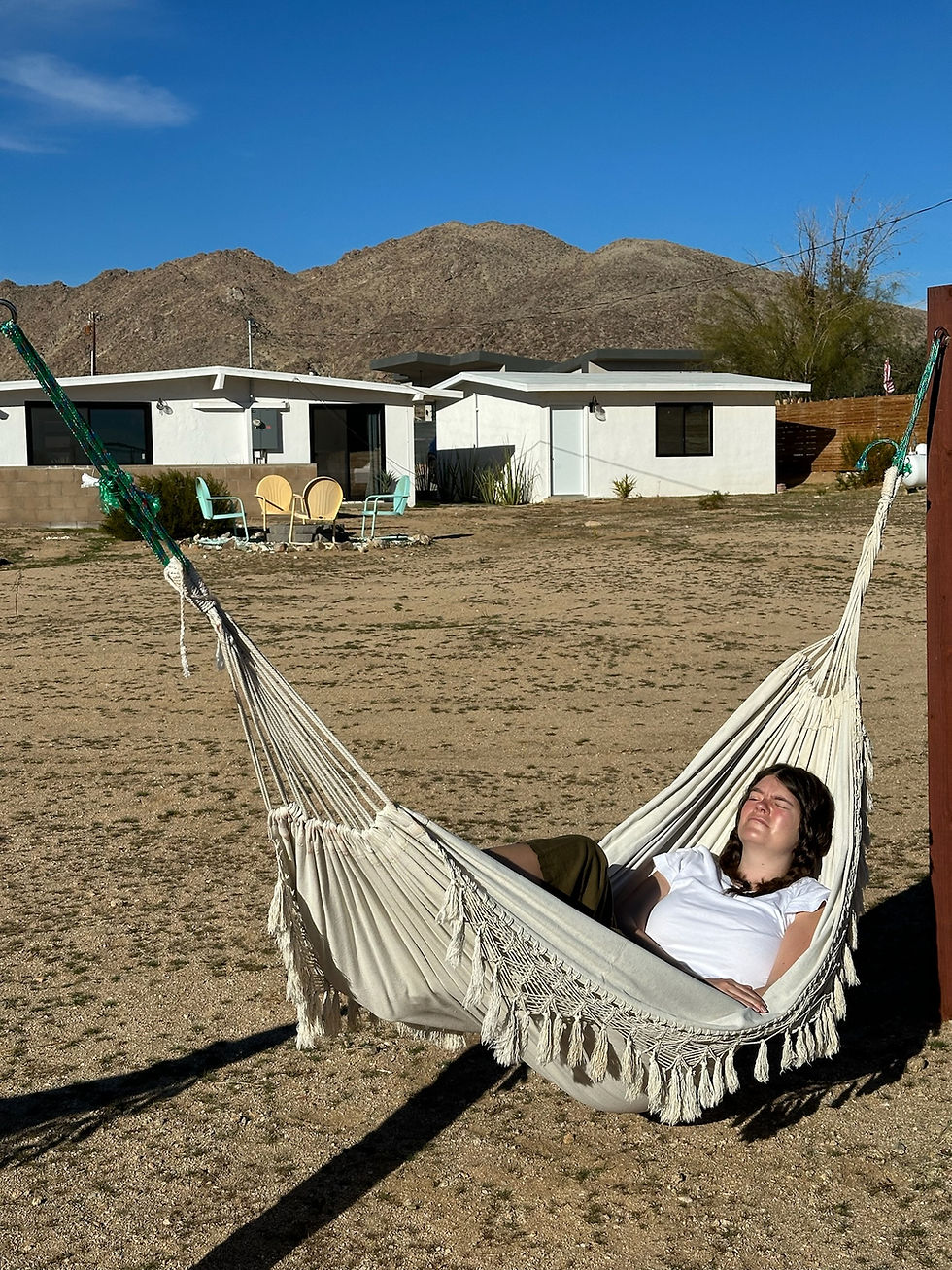 A woman laying in the hammock in the desert