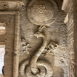 A stone carving of a snake appears on the wall in Catacombs of Kom El Shoqafa