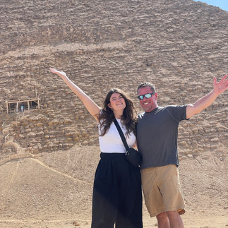 A man and a woman stand in front of the Red Pyramid in Dahshur