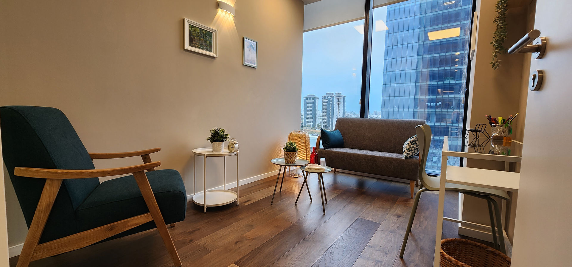 Cozy therapy room, with a couch, small tables, and a big window. therapy room rental
