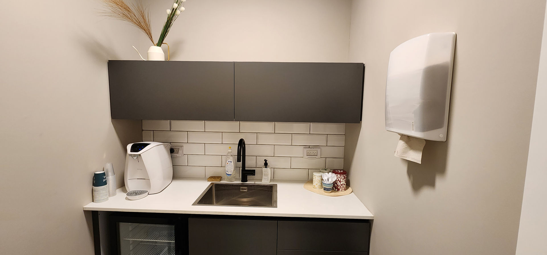 Clean kitchen area with sink and cabinets, therapy room rental for practice.