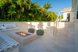 Sunken fire pit lounge with built-in seating beside a custom Naples pool