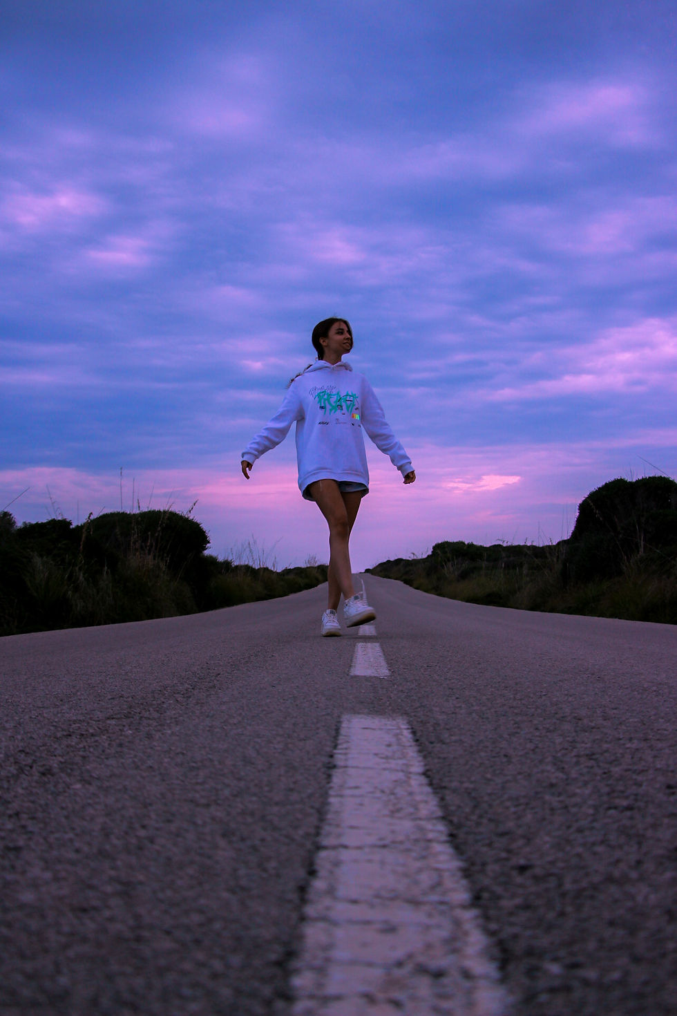 Girl in the middle of a road in a evening in Menorca.