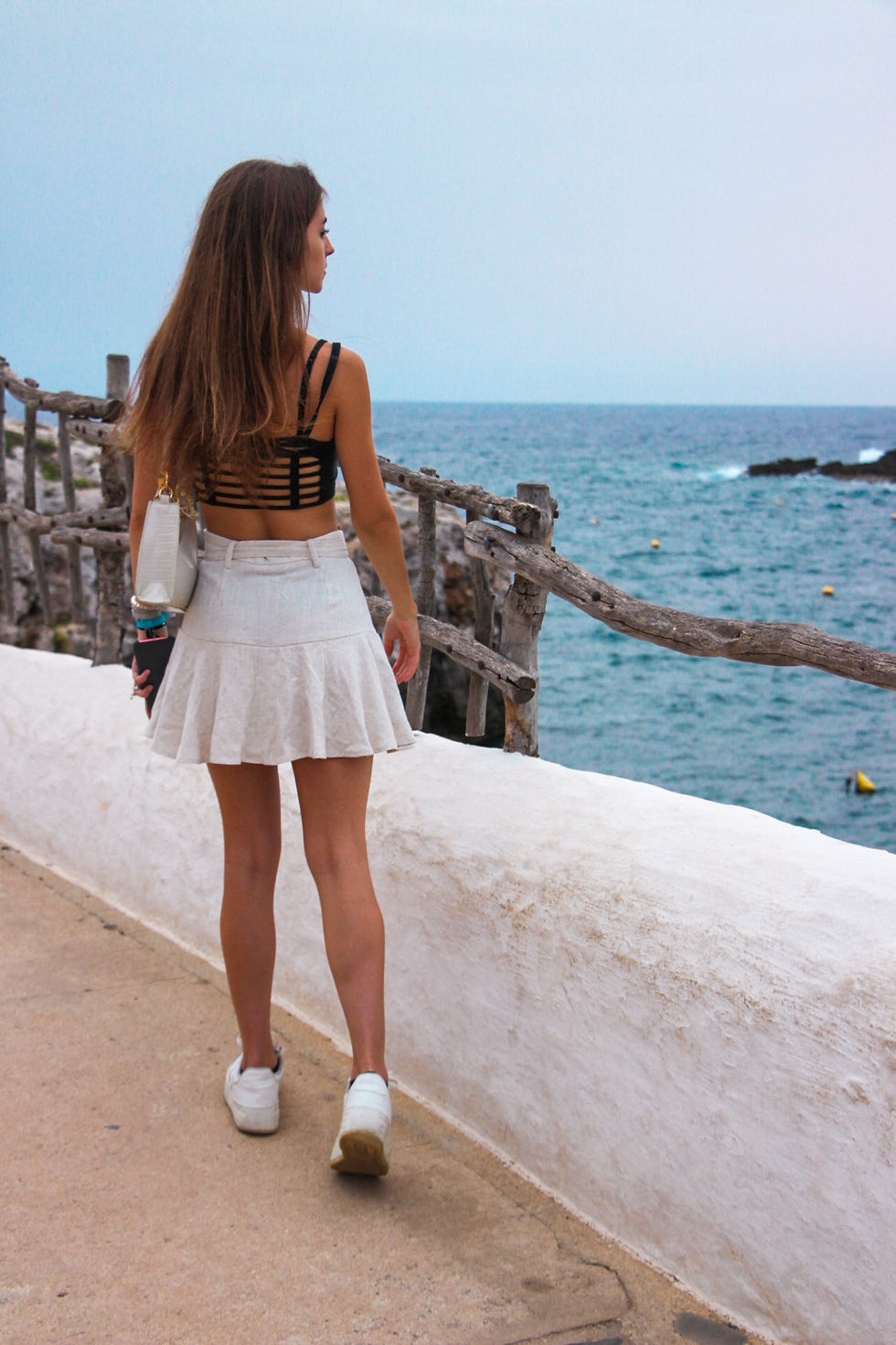 Girl walking around Binibeca while enjoying the sea sights.