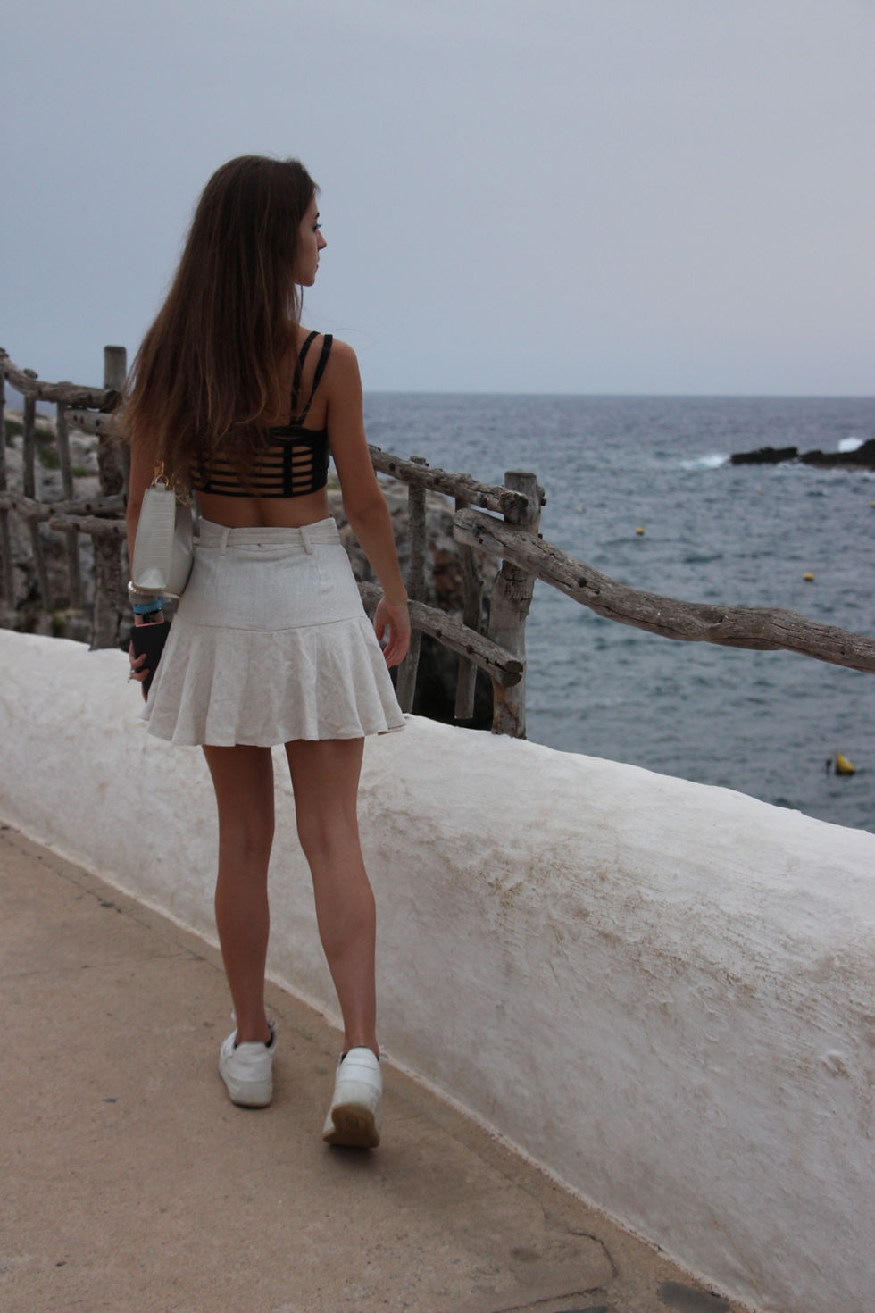 Girl walking around Binibeca while enjoying the sea sights.