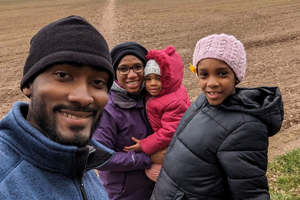 Family of four smile with joy as they spend time together on a family hike.