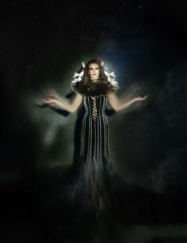 fashion shooting in a black environment with a model wearing glamorous dress