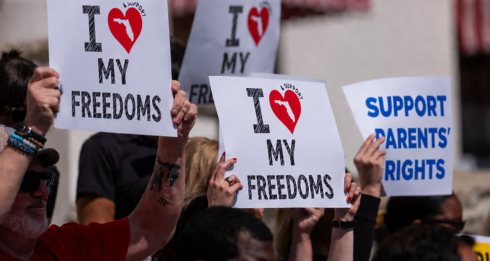 An image of people holding signs that say "I heart my freedoms" (where the heart has the state of Florida in it) and a sign that says "support parents' rights."