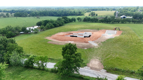 Aerial view of a building foundation under construction in a field.