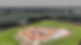 Aerial view of a house foundation under construction on a grassy lot.