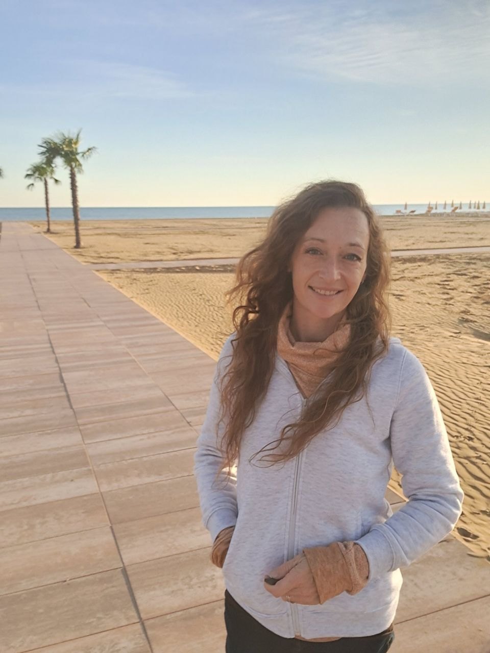 Corinna Laura lächelnd am Strand im Morgenlicht