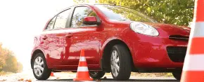 Vehículo de autoescuela en línea practicando circuitos entre conos de circulación