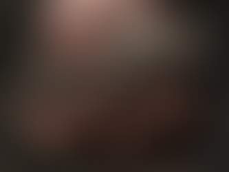 A dirty hand gripping a rough, gray stone in an outdoor setting. Moody, earthy tones with textured details emphasized.