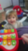 Smiling toddler playing with a colorful toy xylophone