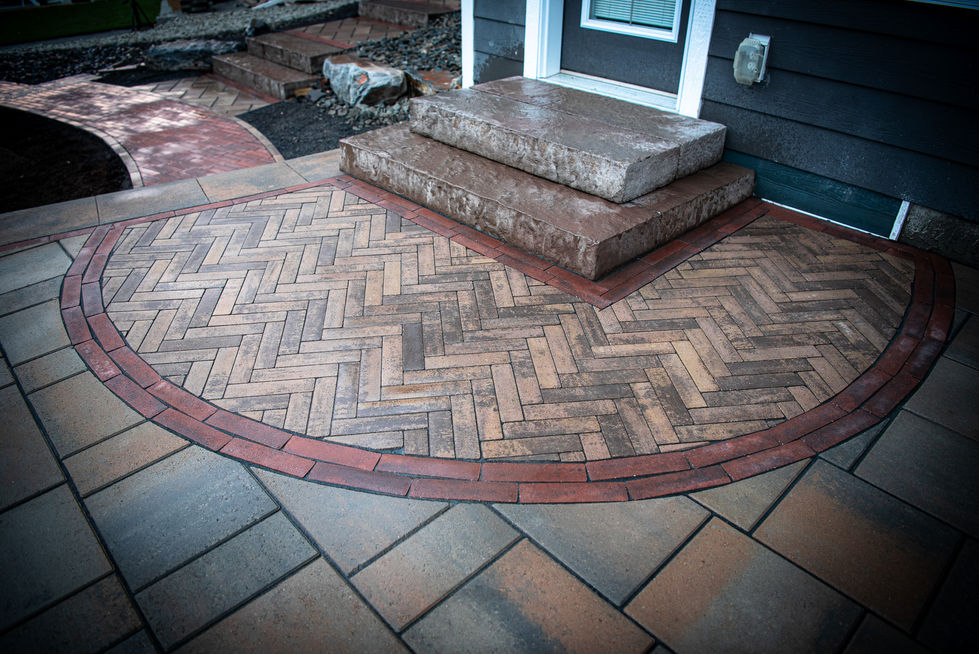 Herringbone brick patio detail with stone steps and contrasting border design