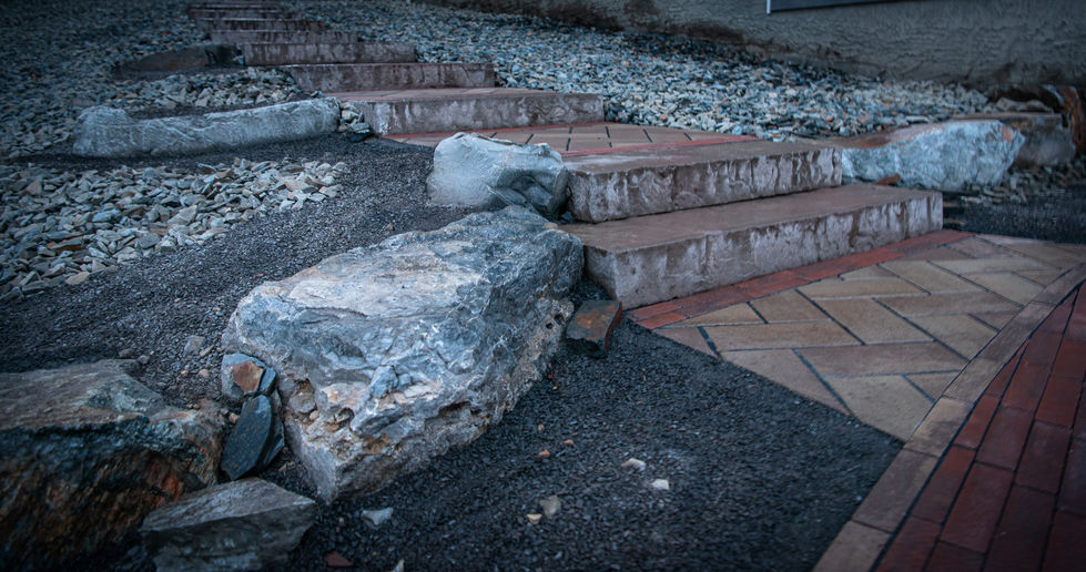 Natural stone steps with large boulder integration and surrounding rock landscaping