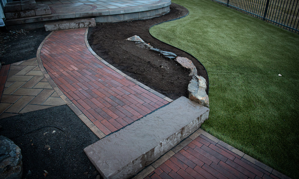 Curved brick walkway with stone edging and smooth transition through landscaped yard