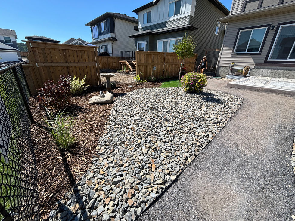 Rock garden landscaping with decorative stone and shrubs in Cochrane Alberta