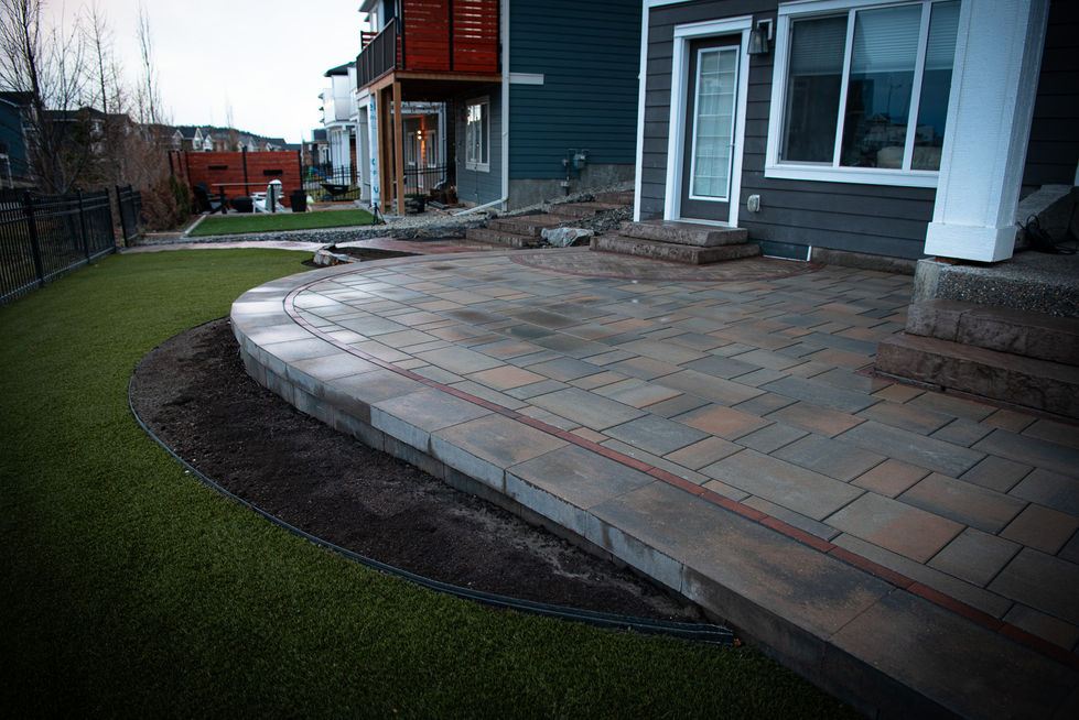 Brick patio with integrated steps and multi-level backyard landscape design