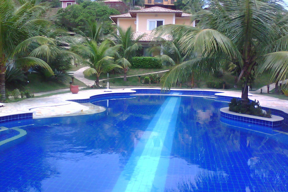 Piscina_do_condomínio_com_casa_no_fundos.jpg